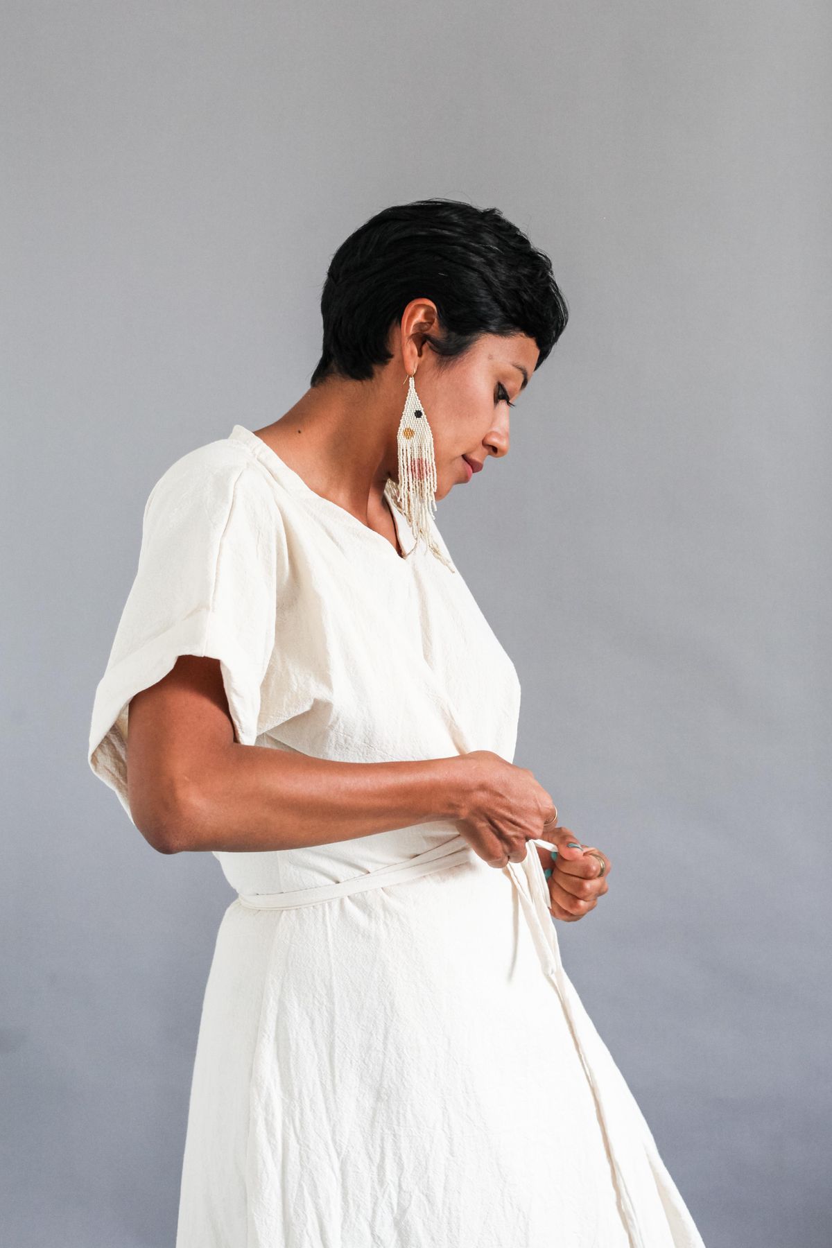 A loose white dress being shaped with a narrow waist tie