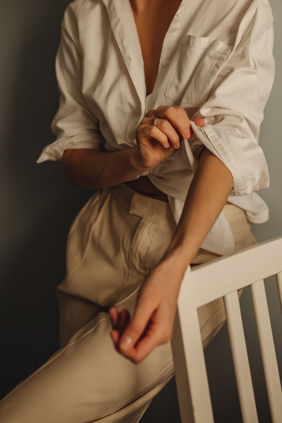 A woman adjusting the cuffs of a white blouse