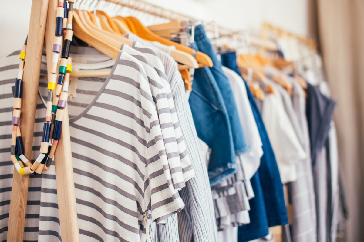 Different garments supported by wooden hangers