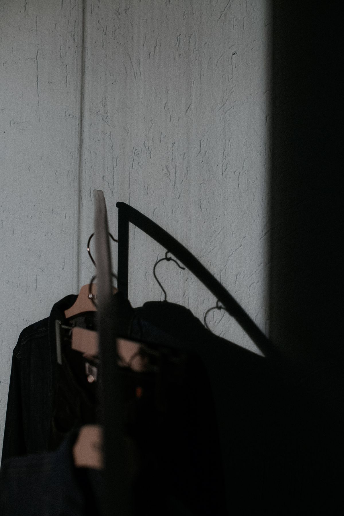 Dark garments on hangers away from direct bright light