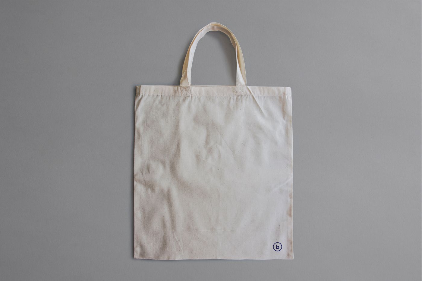 A plain canvas tote bag with two handles
