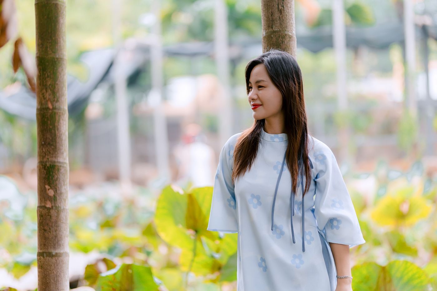 A woman wearing a light floral dress in a garden